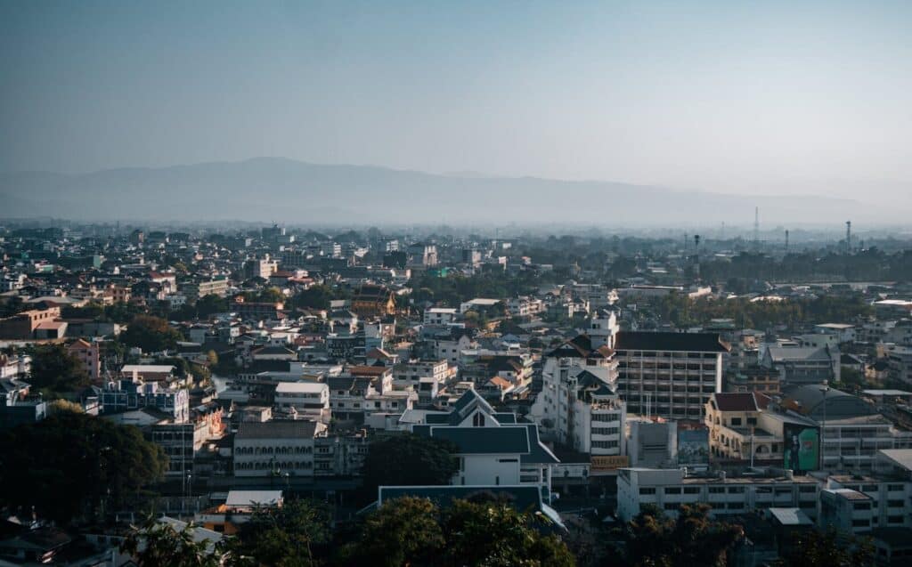 View over Chiang Mai city with mountains in the background and light morning haze.