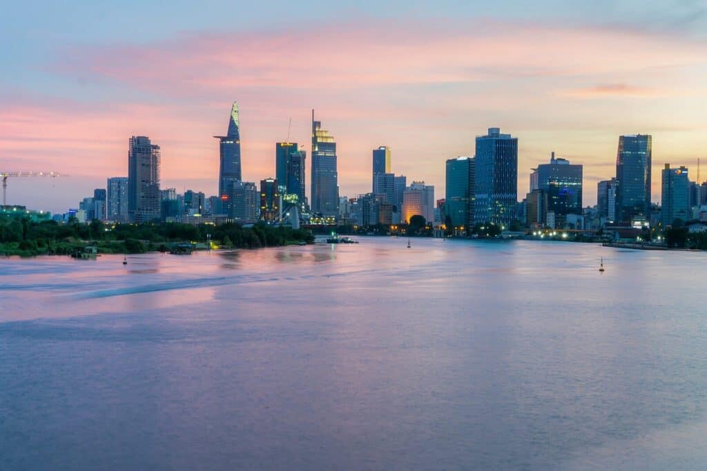 Ho Chi Minh City skyline at sunset with high-rise buildings and river views.