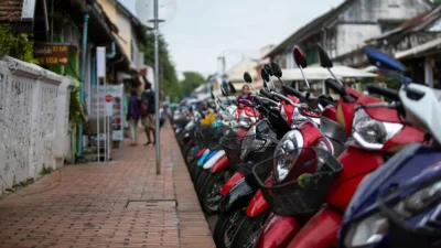 Row of scooters parked along a sidewalk in Thailand, used for a Chiang Mai scooter rental guide.