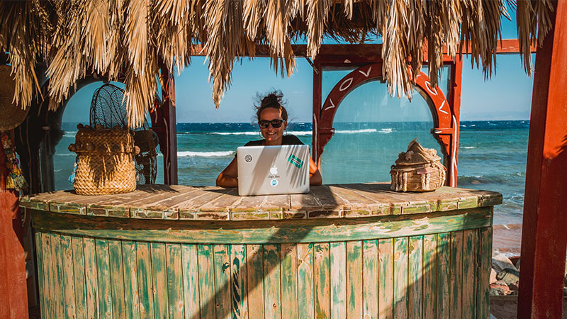 Digital nomad in hut on a beach