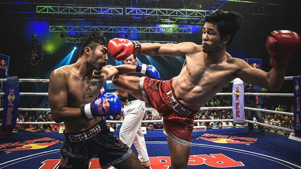 Two Muay Thai fighters exchange strikes during a live fight night in Chiang Mai.