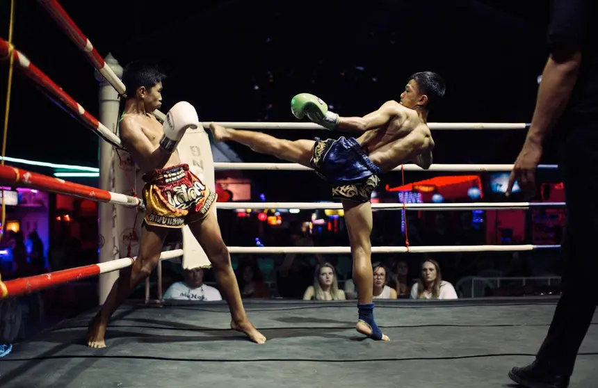 Two young Muay Thai fighters compete in the ring at Loi Kroh Boxing Stadium in Chiang Mai.