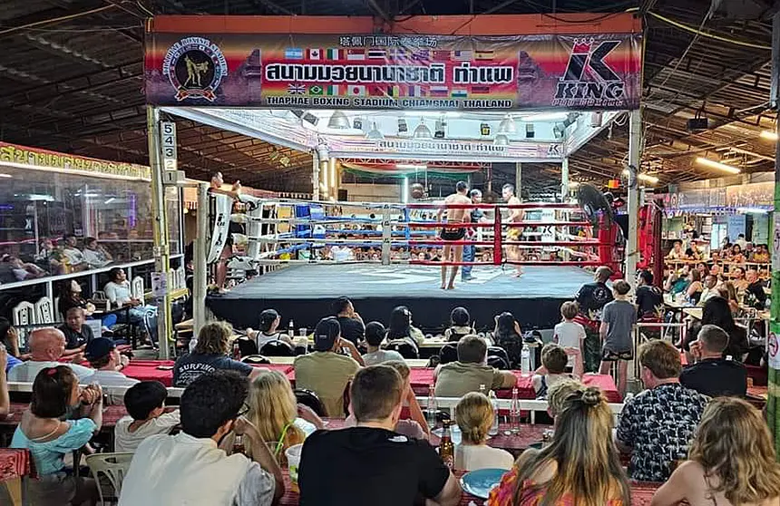 Crowd watching a live Muay Thai fight at Tha Phae Boxing Stadium in Chiang Mai.